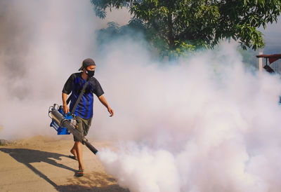 Full length of man doing fumigation work