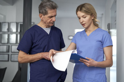 Side view of man using digital tablet while standing at home