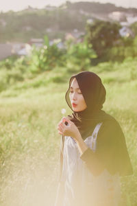 Woman holding while standing on field