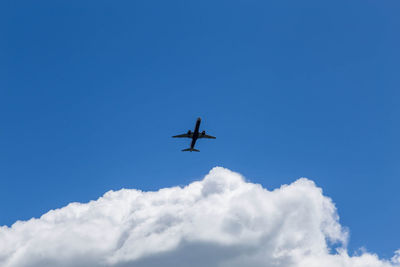 Low angle view of airplane against blue sky