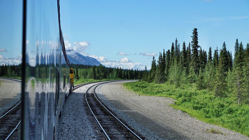 View of railroad tracks by road against sky