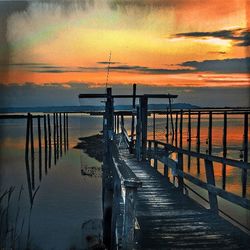 Pier on sea at sunset