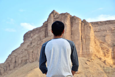 Rear view of man standing on rock