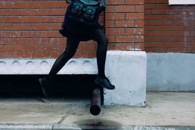 Full length of man standing on brick wall