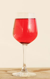 Red wineglass on table against white background