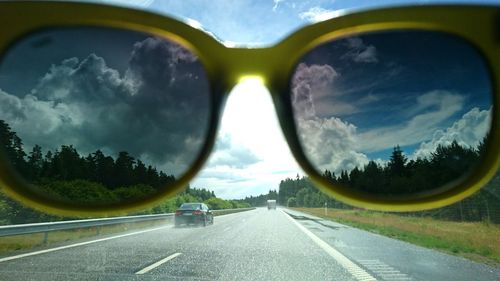 Sky seen through sunglass over road