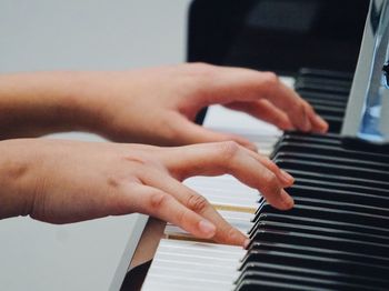 Cropped hands of woman playing piano