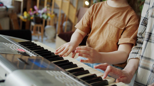 Midsection of woman playing piano