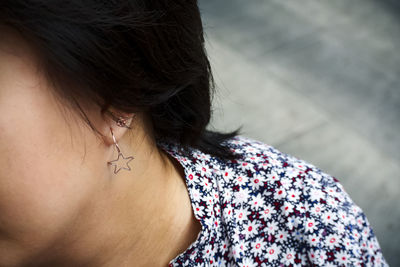 Close-up of woman wearing star shape earring outdoors