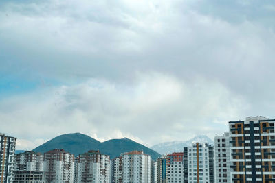 Buildings in city and erciyes mountain against sky