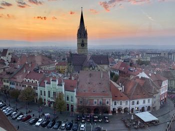 Aerial view of buildings in city at sunset