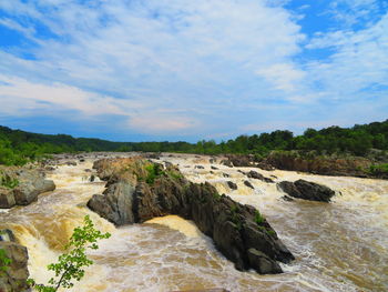 Scenic view of waterfall against sky