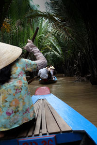 People in boat against trees