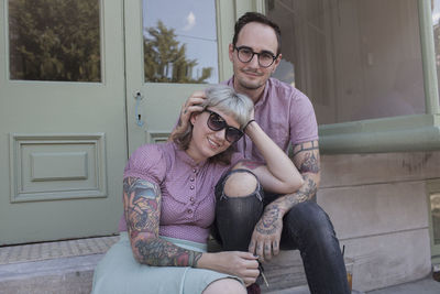 Young couple sitting on stoop in front of a shop