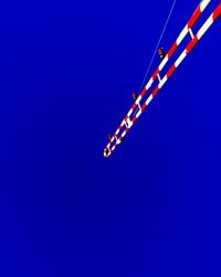 Low angle view of trees against clear blue sky