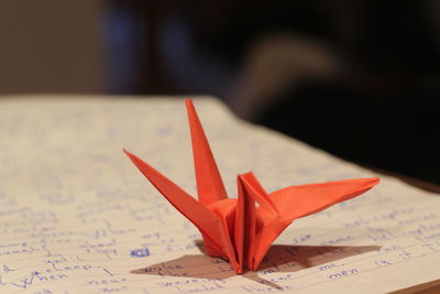 Close-up of paper crane on book