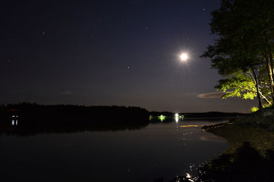 Scenic view of lake against sky at night