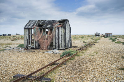 Damaged house at beach against sky