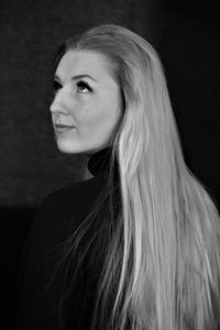 Portrait of beautiful young woman against black background