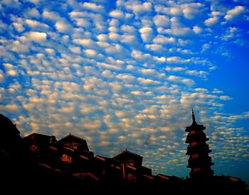 Low angle view of buildings against cloudy sky