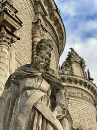 Low angle view of buddha statue against sky