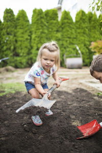 Girl playing on plants against trees