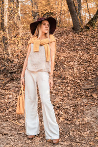 Full length of woman wearing hat standing in forest