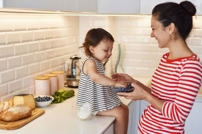 Side view of mother and daughter at home