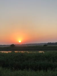 Scenic view of field against sky during sunset