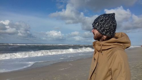 Man standing at beach against sky