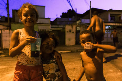 Rear view of shirtless boy with arms raised