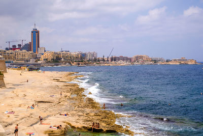 View of buildings at beach against cloudy sky