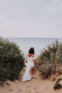 Woman looking at sea against sky