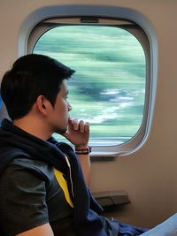 Side view of boy sitting in airplane