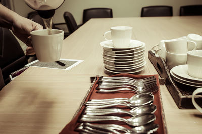 Close-up of person pouring drink at table