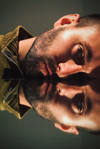 Close-up portrait of young man against gray background