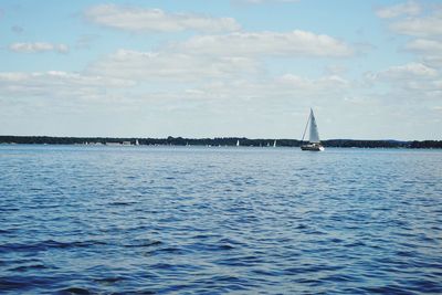 Sailboat sailing on sea against sky