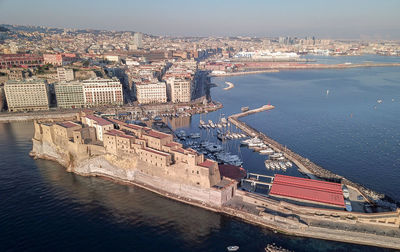 High angle view of buildings by sea against sky