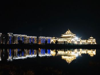 Reflection of buildings in lake at night