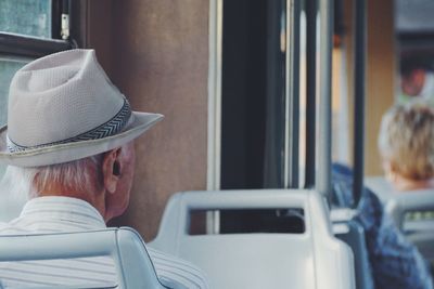 Rear view of woman sitting on bench