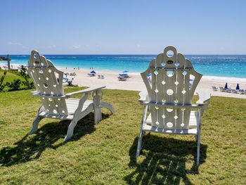 Chairs on beach against sky