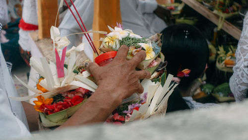 Low angle view of hand holding bouquet of red roses