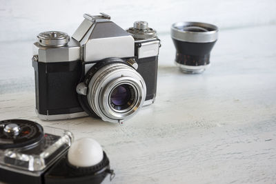 Close-up of camera by light meter on table at home