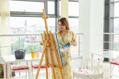 Woman standing on table by window