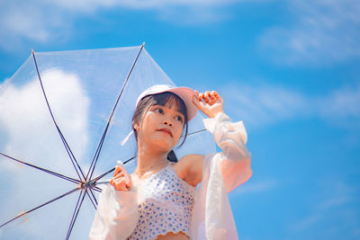Low angle view of girl holding blue sky