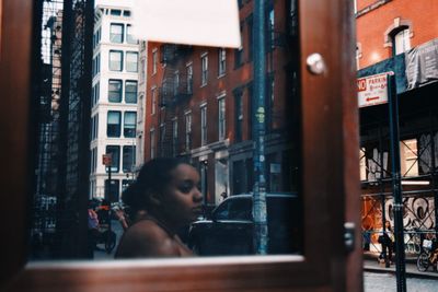 Portrait of woman looking through window