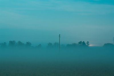 Electricity pylon on field against sky