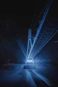 Illuminated bridge over road at night