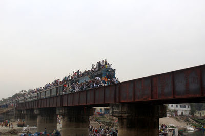 People on bridge against clear sky