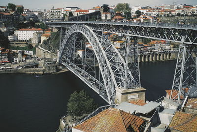 Arch bridge over river against buildings in city